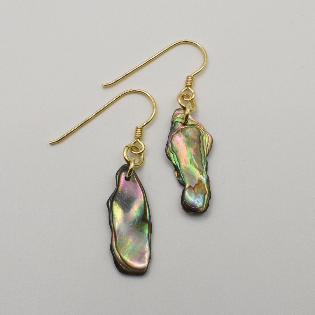 Salty Dreamers' Earrings | Paua Shell Rangi feature handmade, irregularly shaped iridescent pāua shell pendants and gold-plated silver hooks, beautifully displayed on a plain white background.