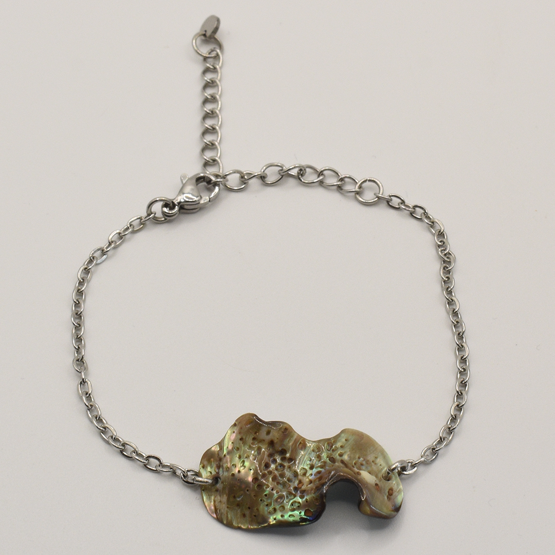 The Salty Dreamers Bracelet | Paua Shell Ra showcases an irregular, iridescent paua shell centerpiece on a silver chain, set against a plain white background.