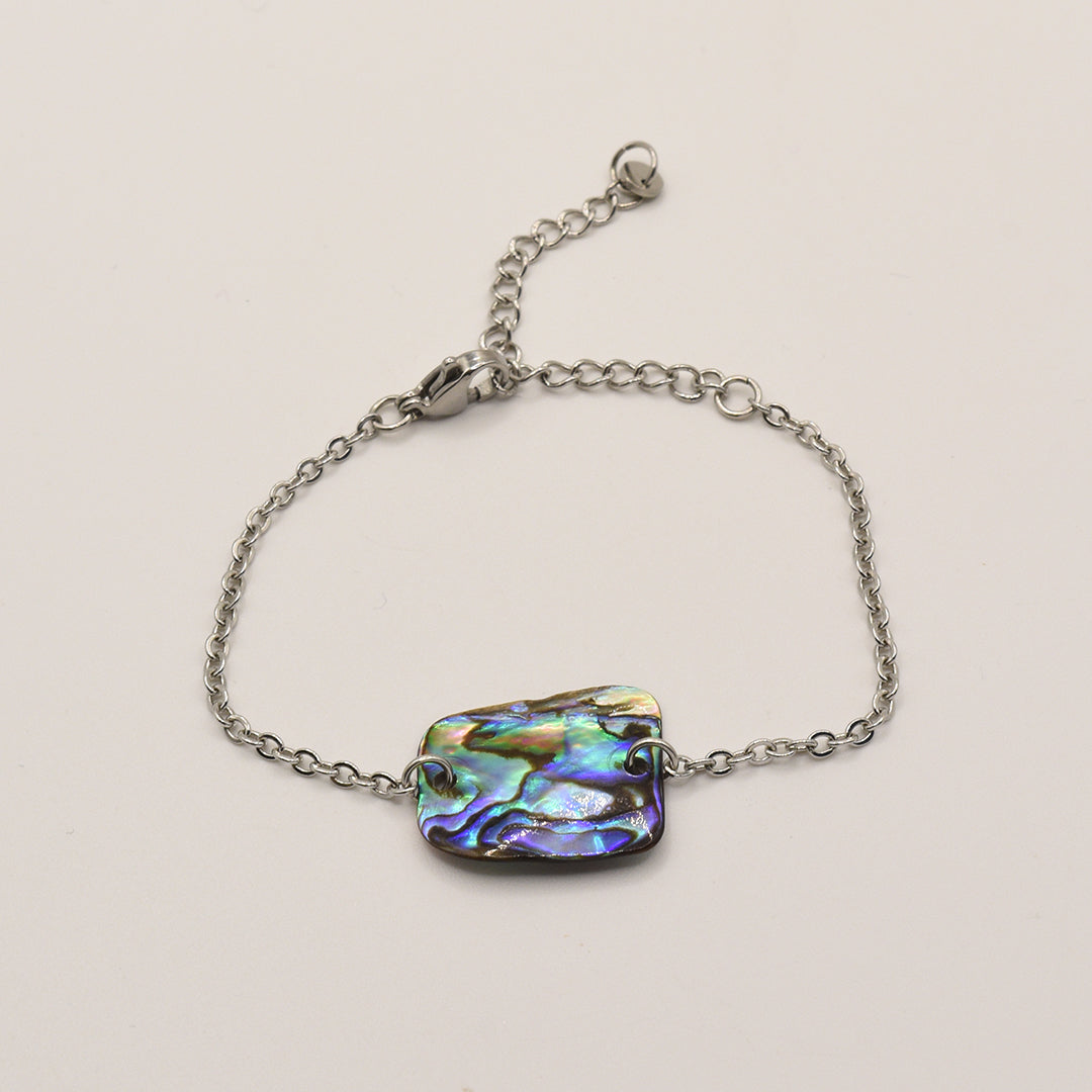 The Bracelet | Paua Shell Marama by Salty Dreamers is a handmade silver chain bracelet with a vibrant pāua shell centerpiece, inspired by New Zealand jewelry traditions and shown on a plain white background.