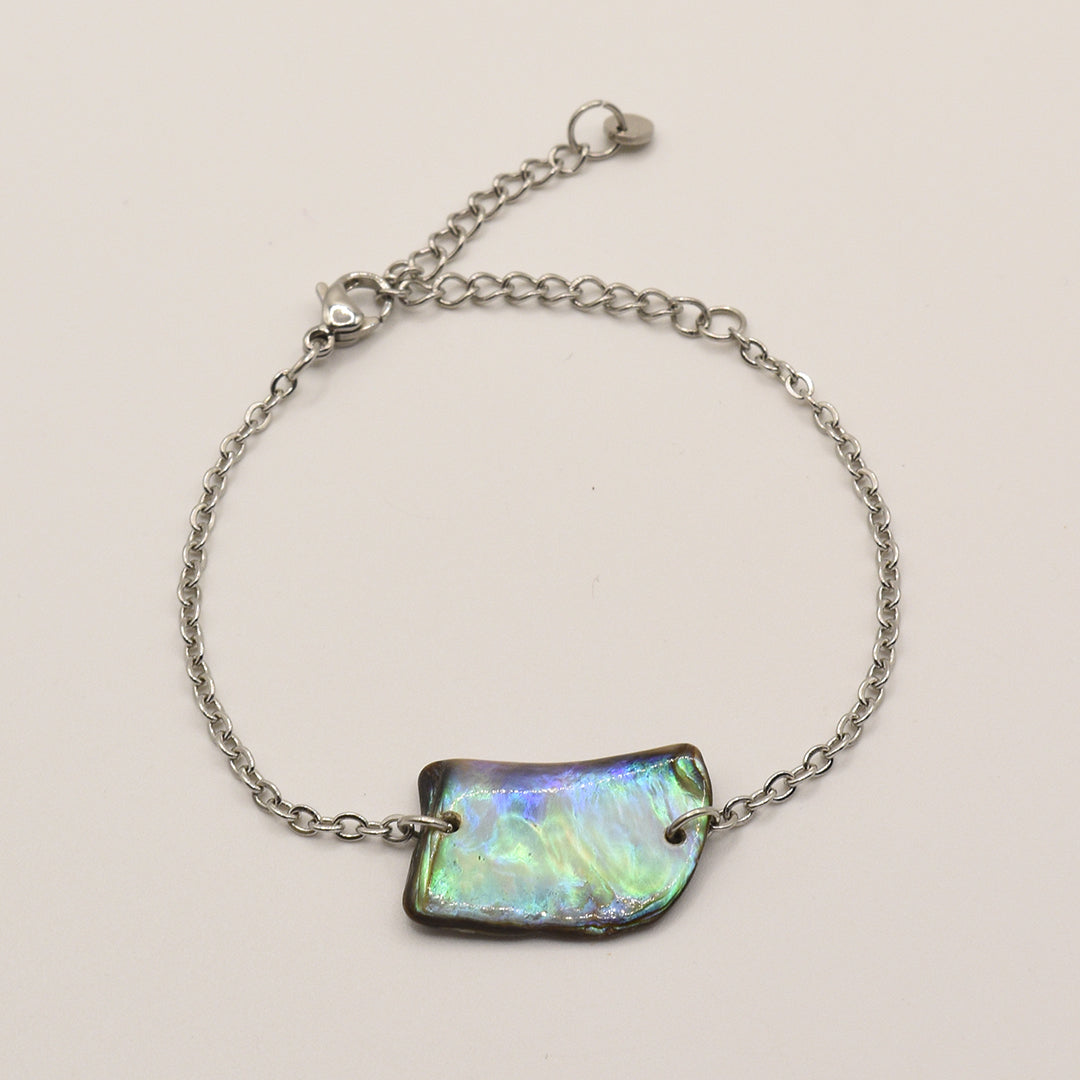 The Bracelet | Paua Shell Atarau by Salty Dreamers features a delicate handmade silver chain, an iridescent rectangular pāua shell centerpiece, and a lobster clasp, shown on a plain light background.