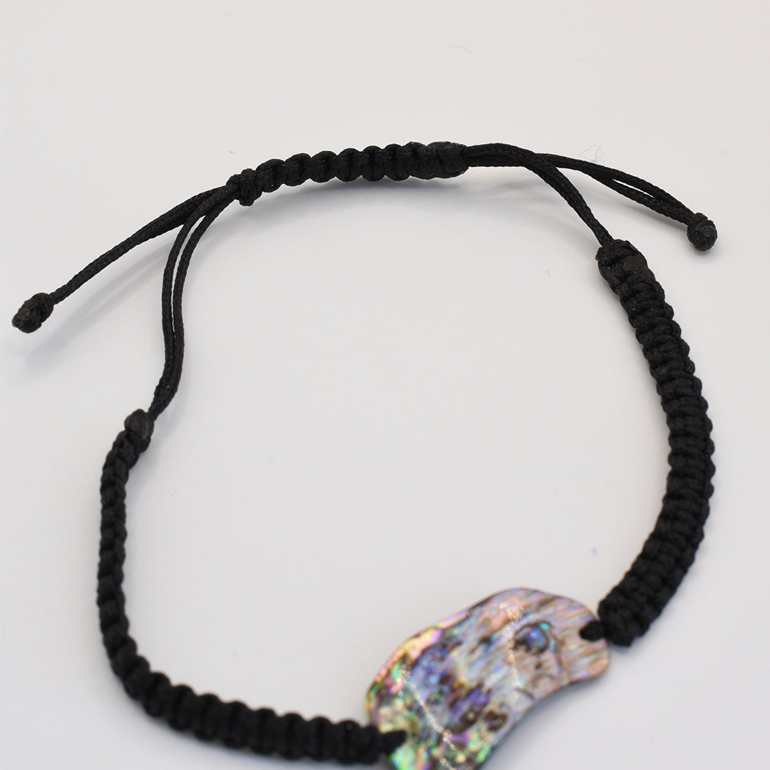 The Salty Dreamers Bracelet | Paua Shell Uru is a handmade black macrame bracelet with a striking New Zealand pāua shell centerpiece, shown on a plain white background.