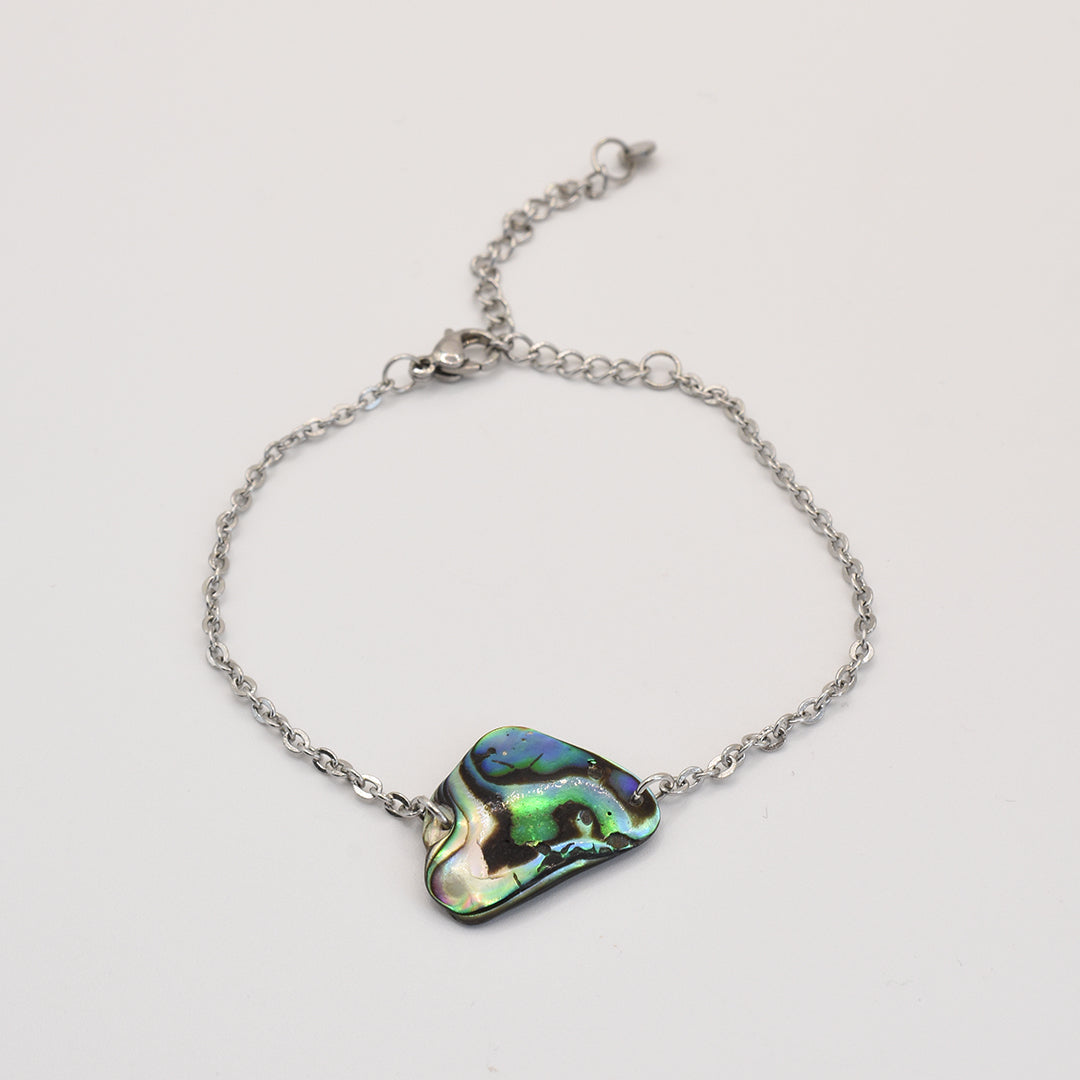 The Bracelet | Paua Shell Tai by Salty Dreamers features an iridescent New Zealand abalone centerpiece on a delicate silver chain—ideal handmade ocean jewelry for any collection.