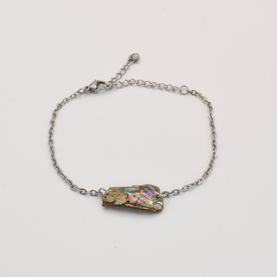 The Salty Dreamers Bracelet | Paua Shell Hine is a handmade silver chain bracelet with an iridescent pāua shell charm, showcased on a plain white background.