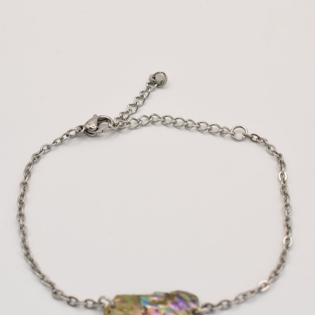 The Salty Dreamers Bracelet | Paua Shell Hine is a silver chain handmade bracelet with an adjustable clasp, shown on a white background. Part of an iridescent New Zealand paua shell accent is visible at the bottom edge.