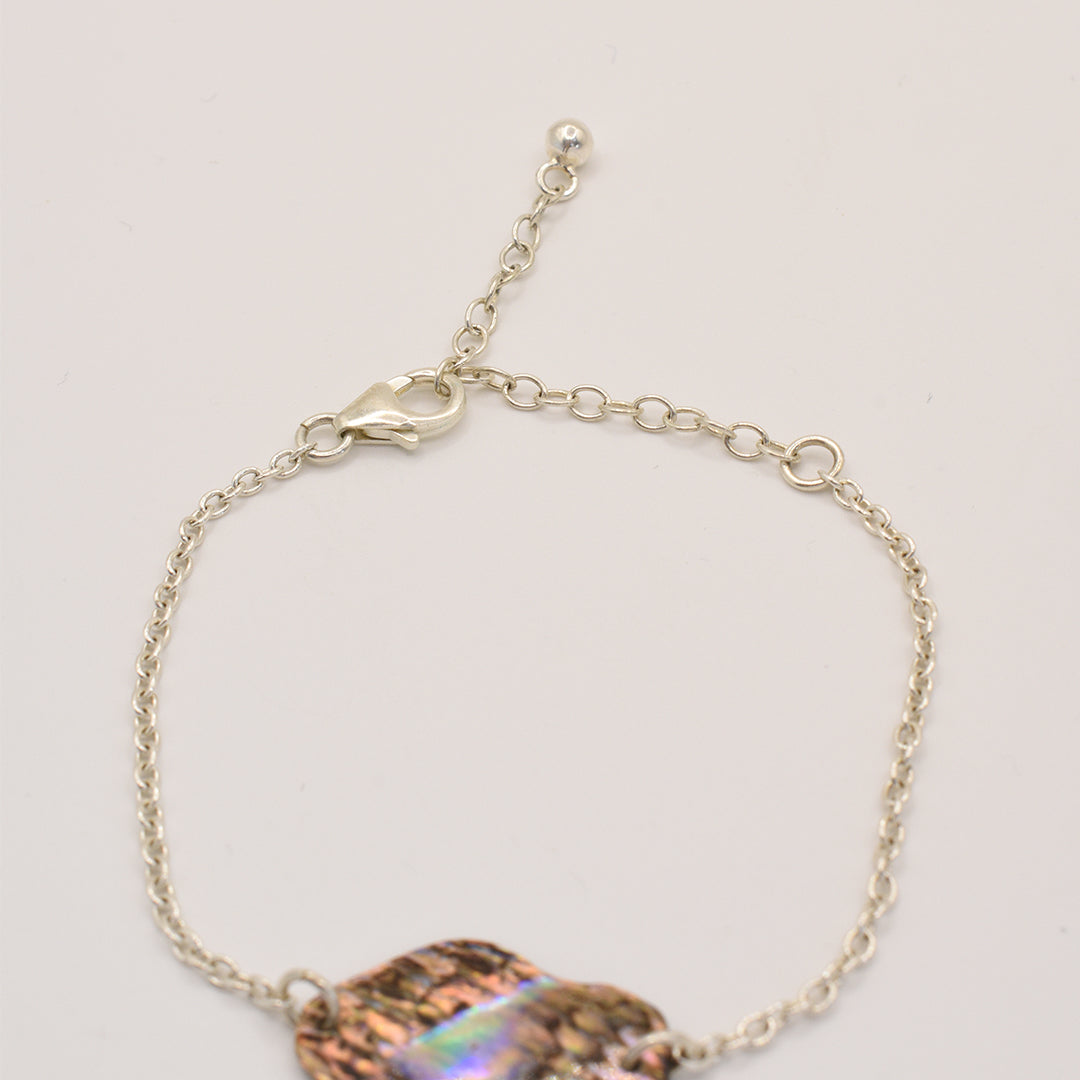 The Salty Dreamers Bracelet | Paua Shell One features 925 silver, an adjustable clasp, and a decorative multicolored abalone shell inspired by handmade New Zealand pāua jewelry, shown against a plain white background.