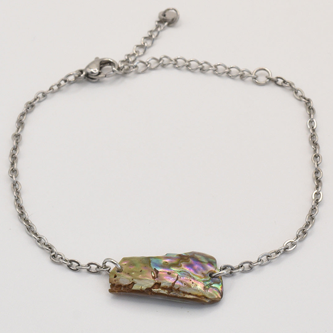 The Salty Dreamers Bracelet | Paua Shell Hine features a handmade silver chain with an iridescent, rectangular New Zealand paua shell centerpiece and lobster clasp, shown on a white background.