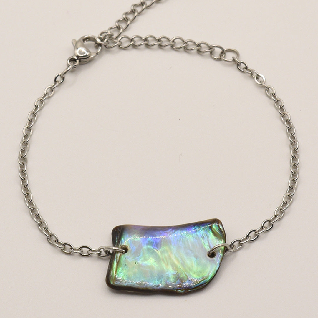 The Bracelet | Paua Shell Atarau by Salty Dreamers features a delicate silver chain and iridescent pāua shell centerpiece with a lobster clasp, showcasing elegant handmade New Zealand craftsmanship.