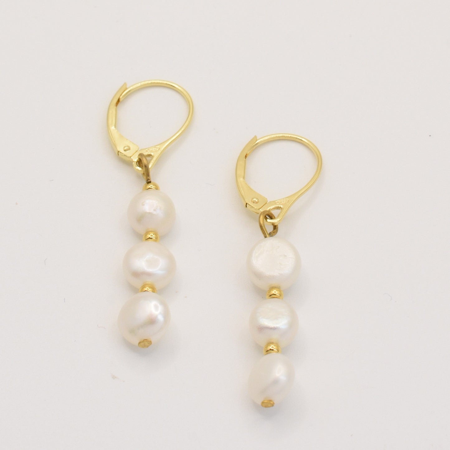 The Prettiest Pearly earrings by Salty Dreamers are handmade gold leverbacks featuring three stacked freshwater pearls with gold bead accents, shown on a white background.