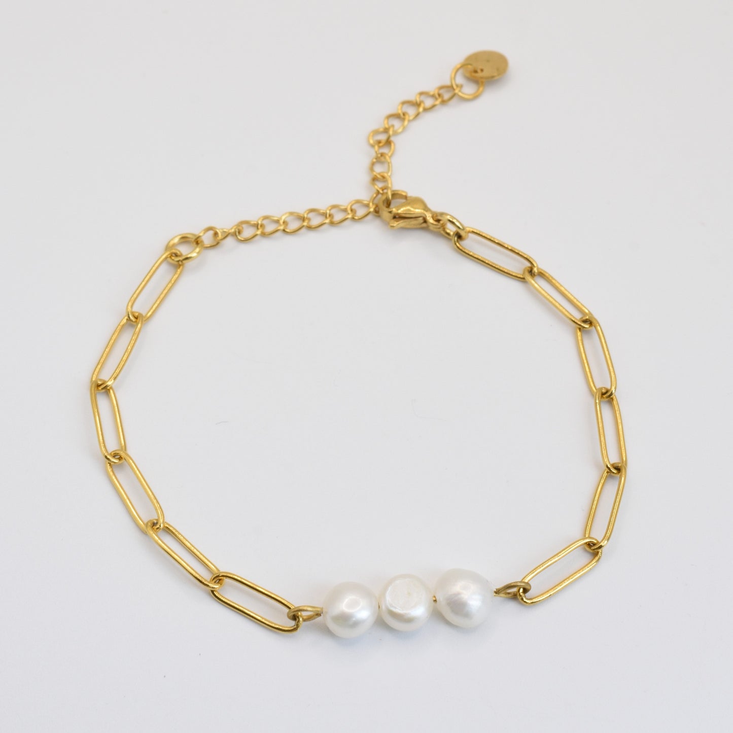 The Salty Dreamers Bracelet | Paperclip Pearly Gold features a gold stainless steel paperclip chain with three center freshwater pearls and an adjustable clasp with a round charm, shown on a plain white background.