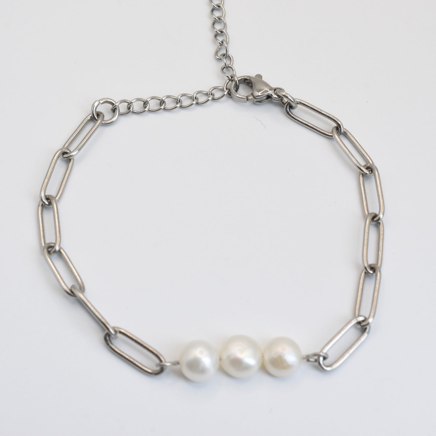 The Salty Dreamers Bracelet | Paperclip Pearly Silver is a handmade pearl bracelet with large oval silver links and three freshwater pearls at the center, perfect modern surfer jewelry, shown on a white background.