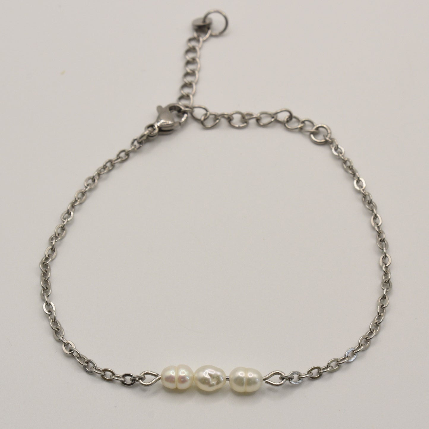 The Pretty Pearly Silver bracelet by Salty Dreamers is a delicate handmade piece with three white freshwater pearls on a silver chain and an adjustable clasp, shown on a plain white background.
