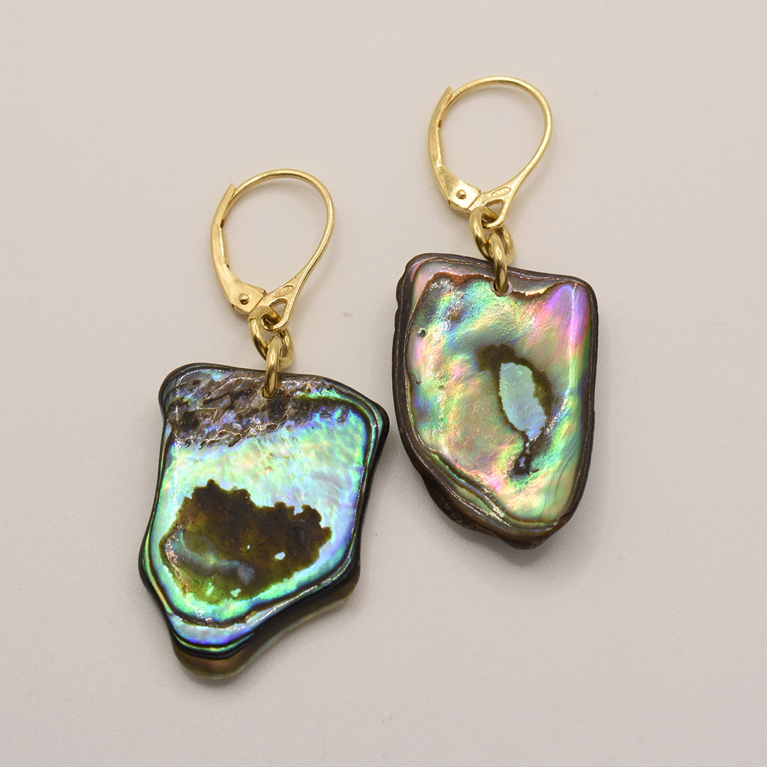 Salty Dreamers’ Earrings | Paua Shell Korohea feature handmade, iridescent pāua shell pendants with gold-plated 925-silver lever-back hooks, shown against a light backdrop.