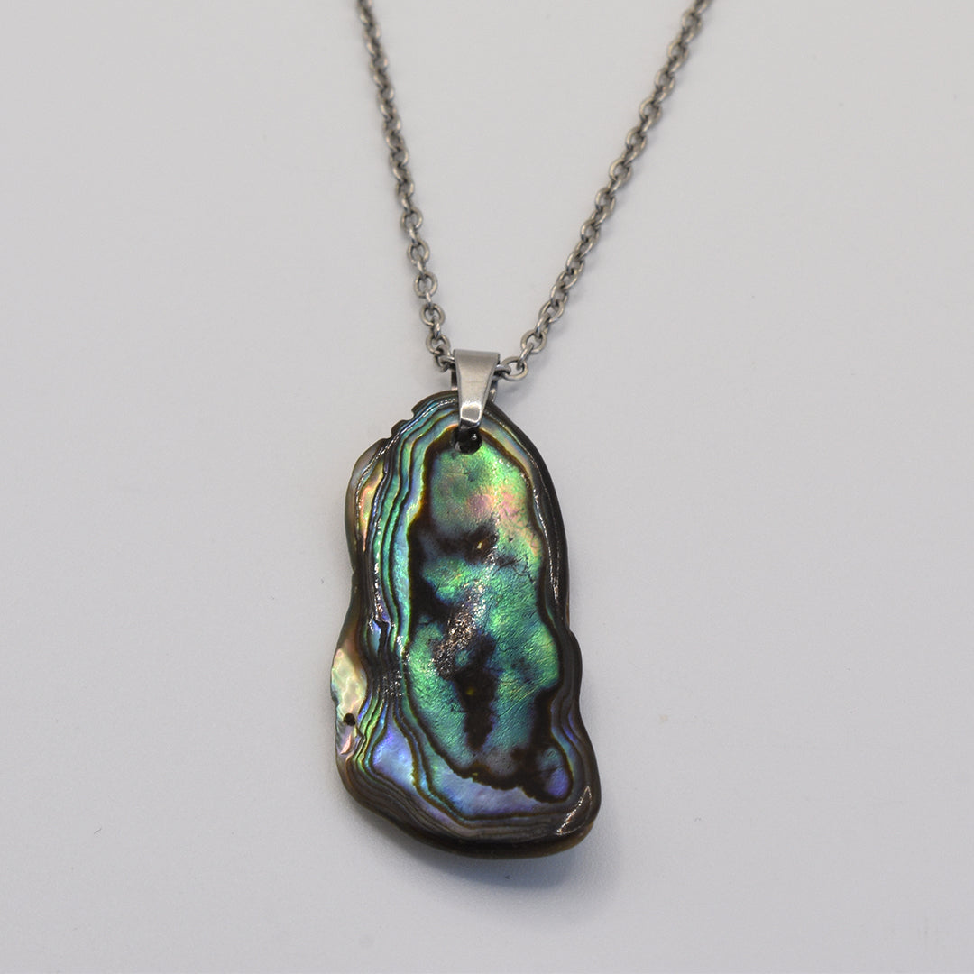 The Salty Dreamers Necklace | Paua Shell Takaro is a handmade silver chain necklace with a polished, iridescent pāua shell pendant showing green, blue, and purple hues on a plain white background.