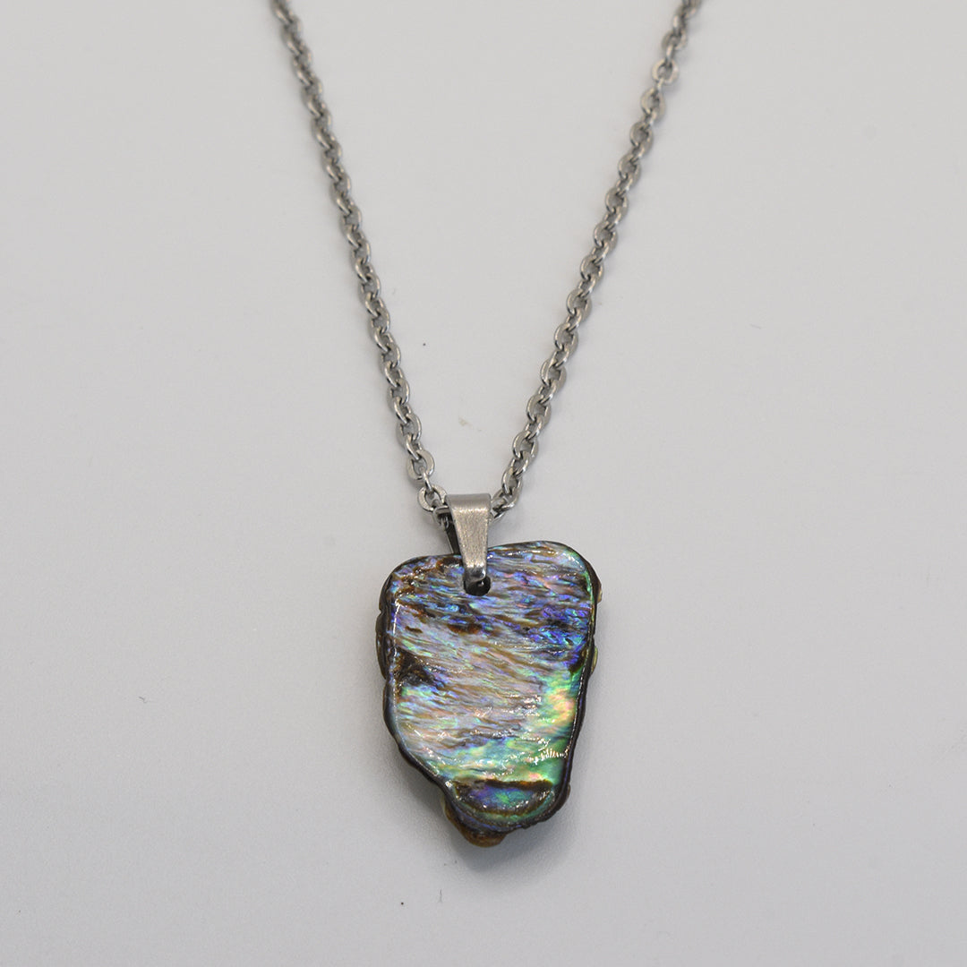 The Salty Dreamers Necklace | Paua Shell Pae is a handmade silver chain with an iridescent pāua shell pendant in blue, green, and purple tones—a stunning piece of New Zealand jewelry shown on a plain white background.