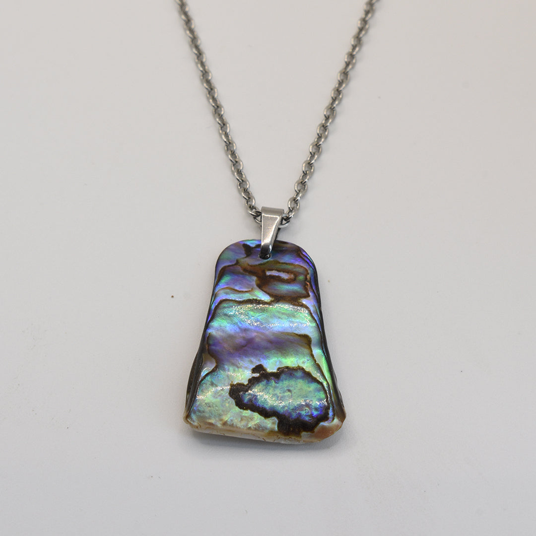 The Necklace | Paua Shell Whenua by Salty Dreamers is a silver stainless steel necklace with a rectangular, multicolored New Zealand abalone shell pendant displaying iridescent green, blue, and purple on white.