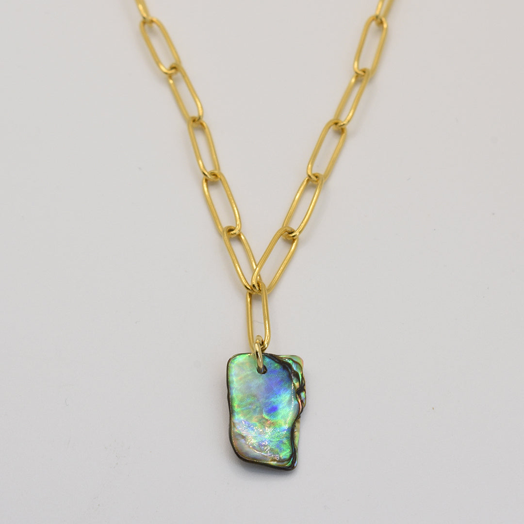 The Salty Dreamers Necklace | Paua Shell Tautahi features large gold links and a rectangular iridescent pāua shell pendant—a stunning handmade jewelry piece shown on a plain white background.