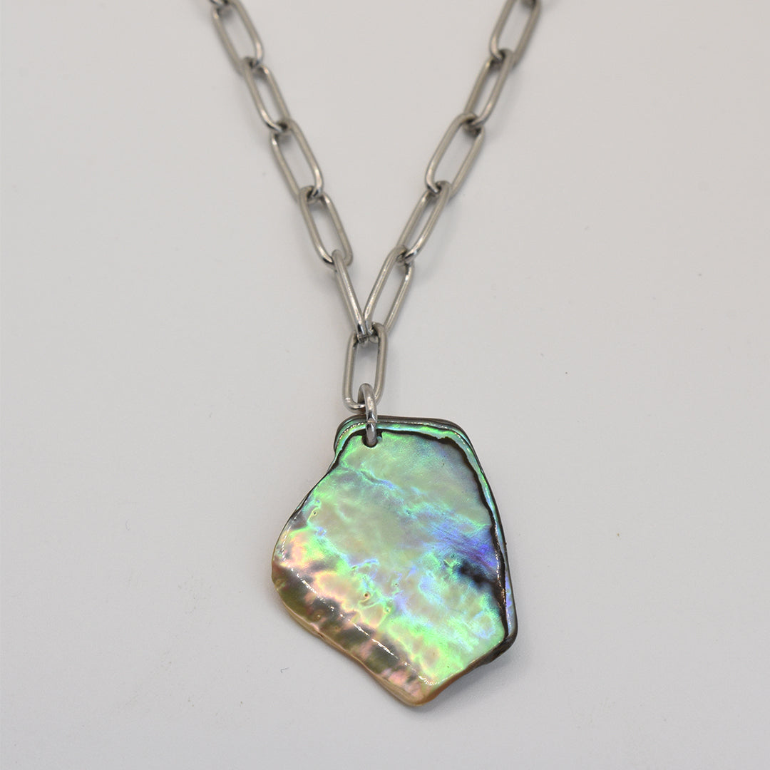 The Salty Dreamers Necklace | Paua Shell Koura showcases a large, iridescent pāua shell pendant on a silver chain, displayed against a plain white background.