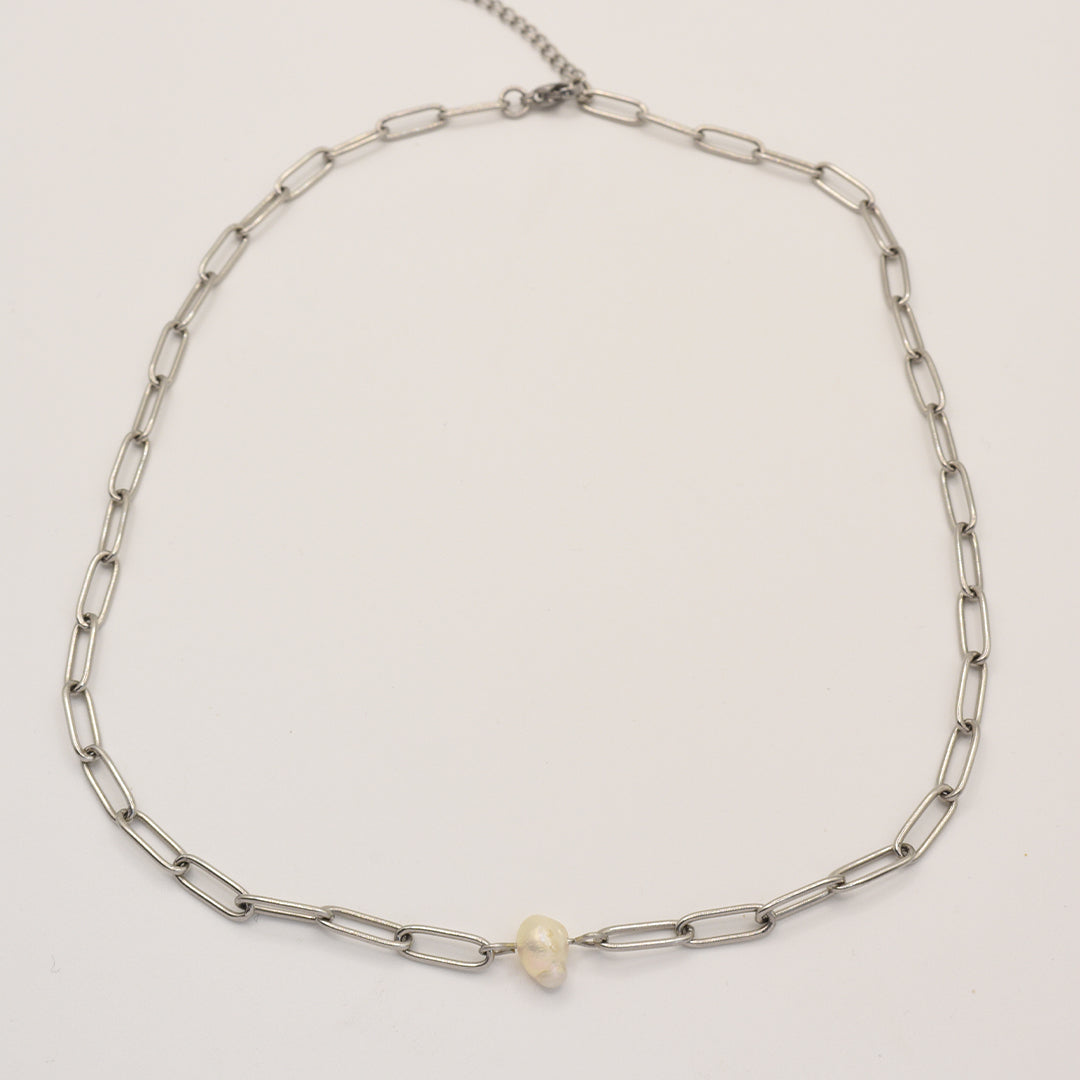 The Salty Dreamers Necklace | Paperclip Cutie Silver features elongated silver links and a single small freshwater pearl at the center, elegantly showcased on a plain white background.