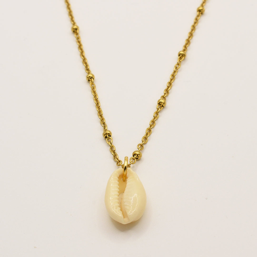 The Necklace | Simplified Cowrie Gold by Salty Dreamers features a handmade gold chain with a striking white cowrie pendant, elegantly displayed on a plain white background.