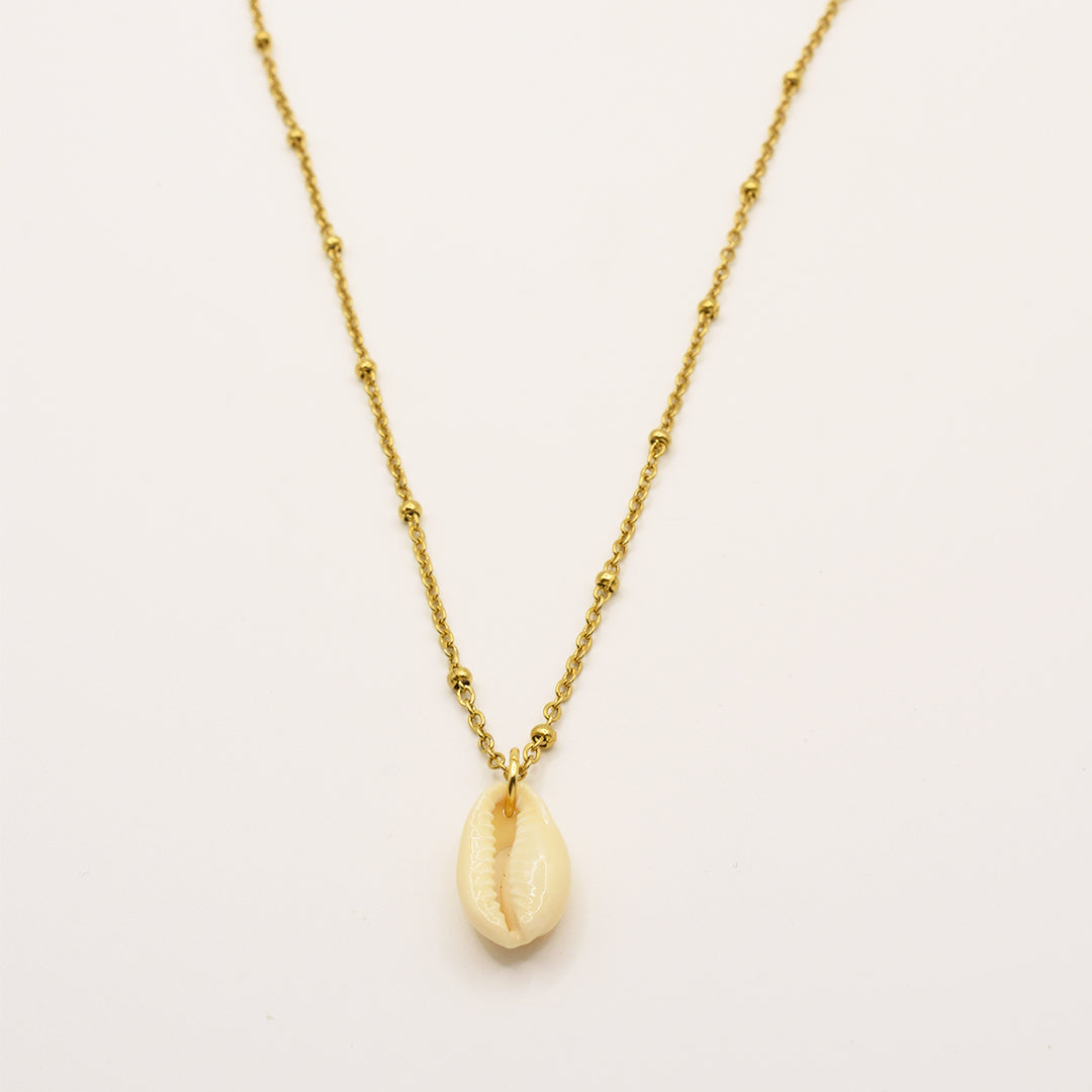 The Necklace | Simplified Cowrie Gold by Salty Dreamers is a handmade gold chain necklace with subtle bead accents and a single cream cowrie pendant, inspired by classic puka shell designs, shown on a plain white background.
