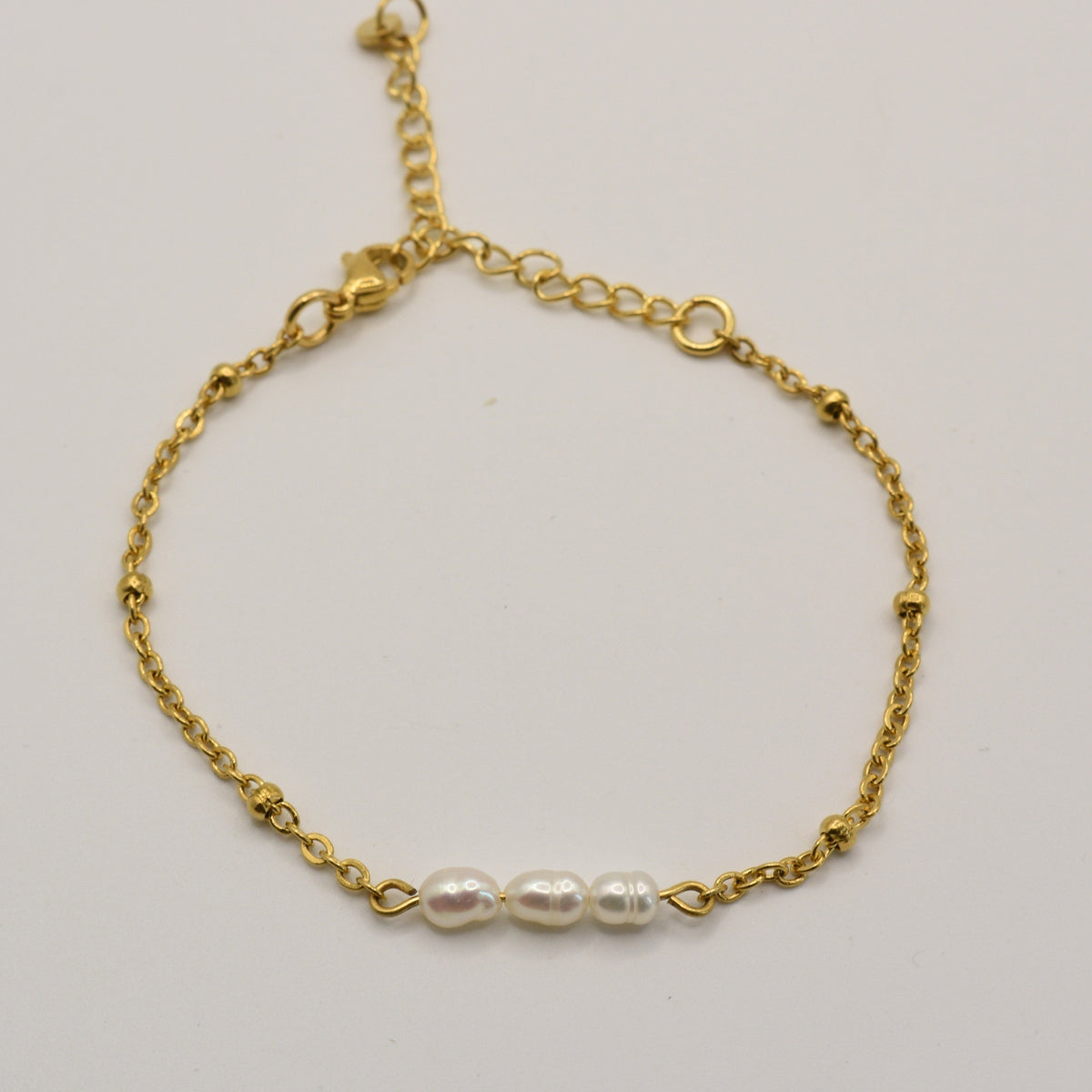 Nahaufnahme Armband Pretty Pearly Gold: drei kleine Süßwasserperlen an goldfarbener Kette