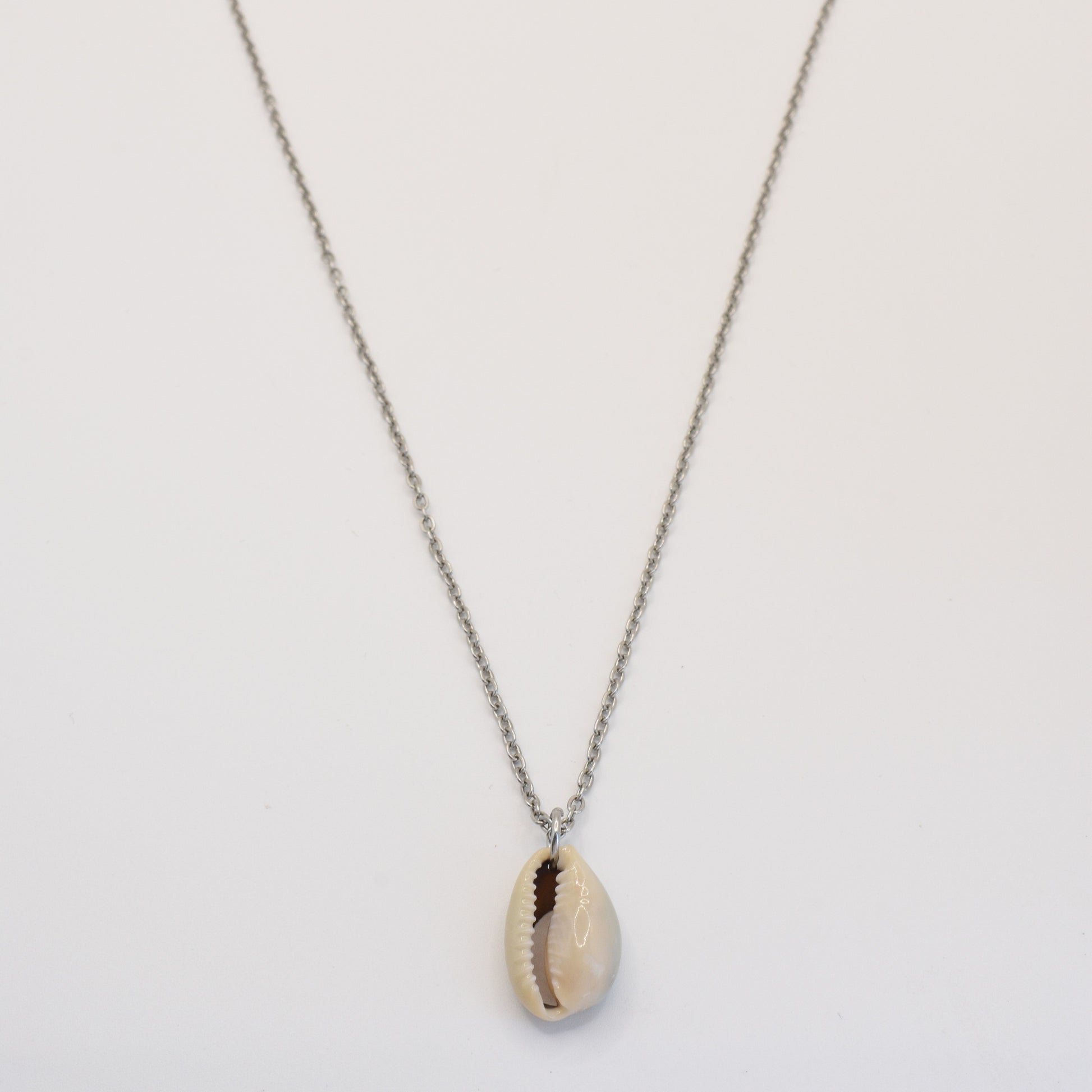 The Necklace | Simplified Cowrie Silver by Salty Dreamers features a handmade silver chain with a single cowrie pendant, beautifully displayed against a plain white background.