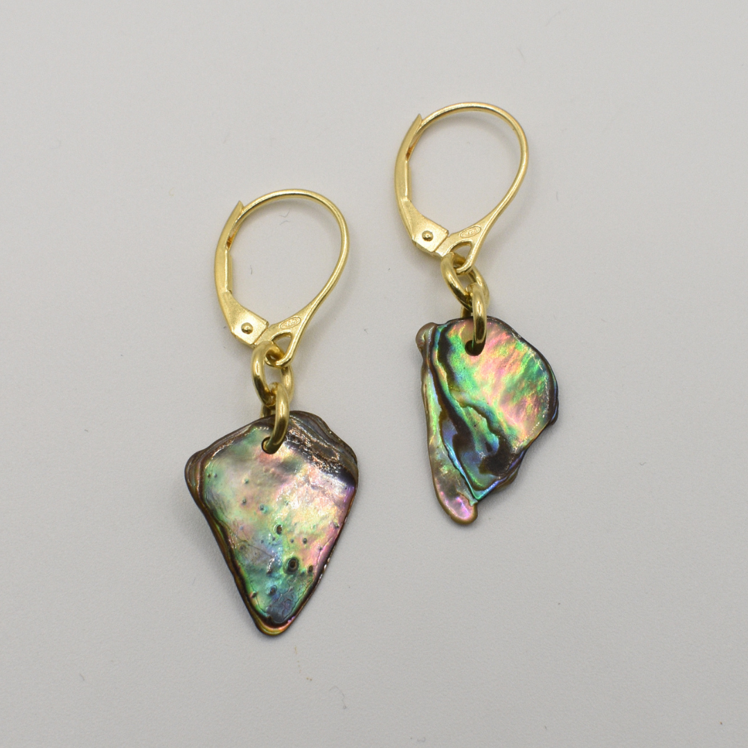 Salty Dreamers' Earrings | Paua Shell Hihiri feature gold hooks with asymmetrical paua shell drops—handmade beach jewelry—shown on a plain light background.