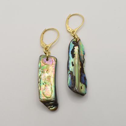 Salty Dreamers’ Earrings | Paua Shell One are gold hook earrings with irregular rectangular New Zealand paua shell pieces and an iridescent multicolored finish, shown against a plain white background.