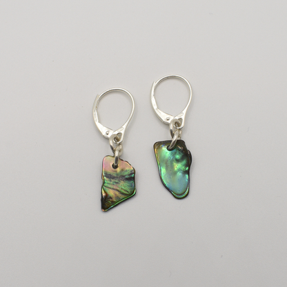 Salty Dreamers’ Earrings | Paua Shell Ra are silver leverback earrings featuring irregular, iridescent pāua shell pendants, shown on a plain white background.