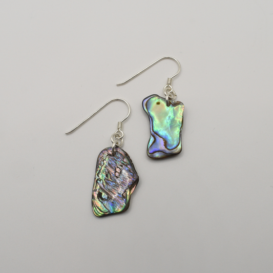 Salty Dreamers’ Earrings | Paua Shell Ruru: Handmade dangly earrings featuring irregular pāua shell pieces in iridescent green, blue, and purple hues, displayed on a plain white background.