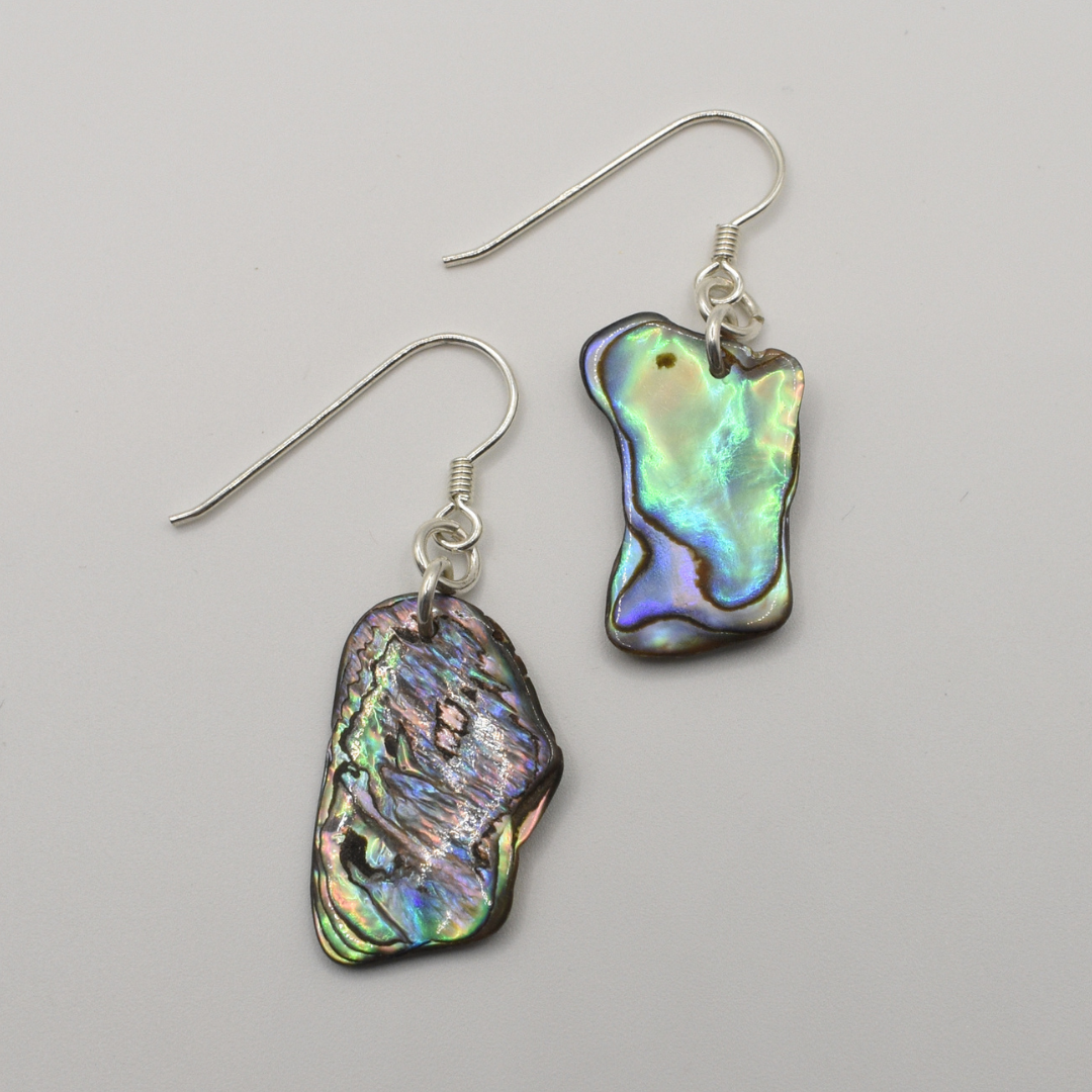 The Earrings | Paua Shell Ruru by Salty Dreamers feature handmade dangle earrings with silver hooks and unique, iridescent paua shell pendants—perfect for lovers of natural beauty. Shown on a plain white background.