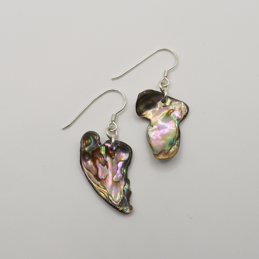 Salty Dreamers’ Earrings | Paua Shell Whenua feature handmade, irregularly shaped iridescent pāua shell pendants and 925 silver hooks, shown on a plain white background.