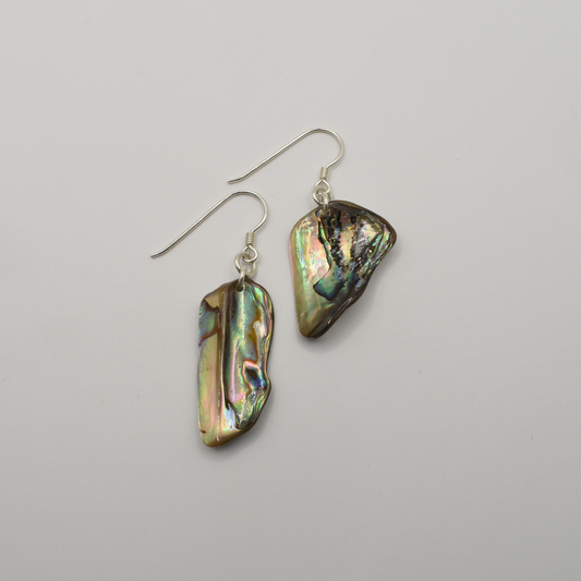 Salty Dreamers’ Earrings | Paua Shell Tieke: Handmade silver dangle earrings with iridescent, irregular pāua shell pieces on silver hooks, shown against a plain white background.