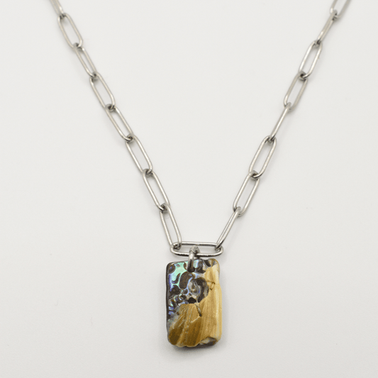 The Necklace | Paua Shell Ngaru by Salty Dreamers features large silver rectangular links and a vibrant paua shell pendant in yellow, brown, and blue tones. This handmade New Zealand piece is shown on a white background.