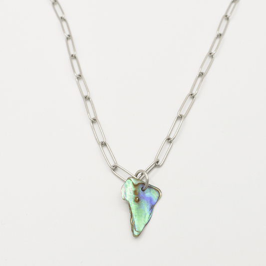 The Salty Dreamers Necklace | Paua Shell Pae features elongated silver links and an iridescent, irregular pāua shell pendant—handmade New Zealand jewelry displayed on a white background.