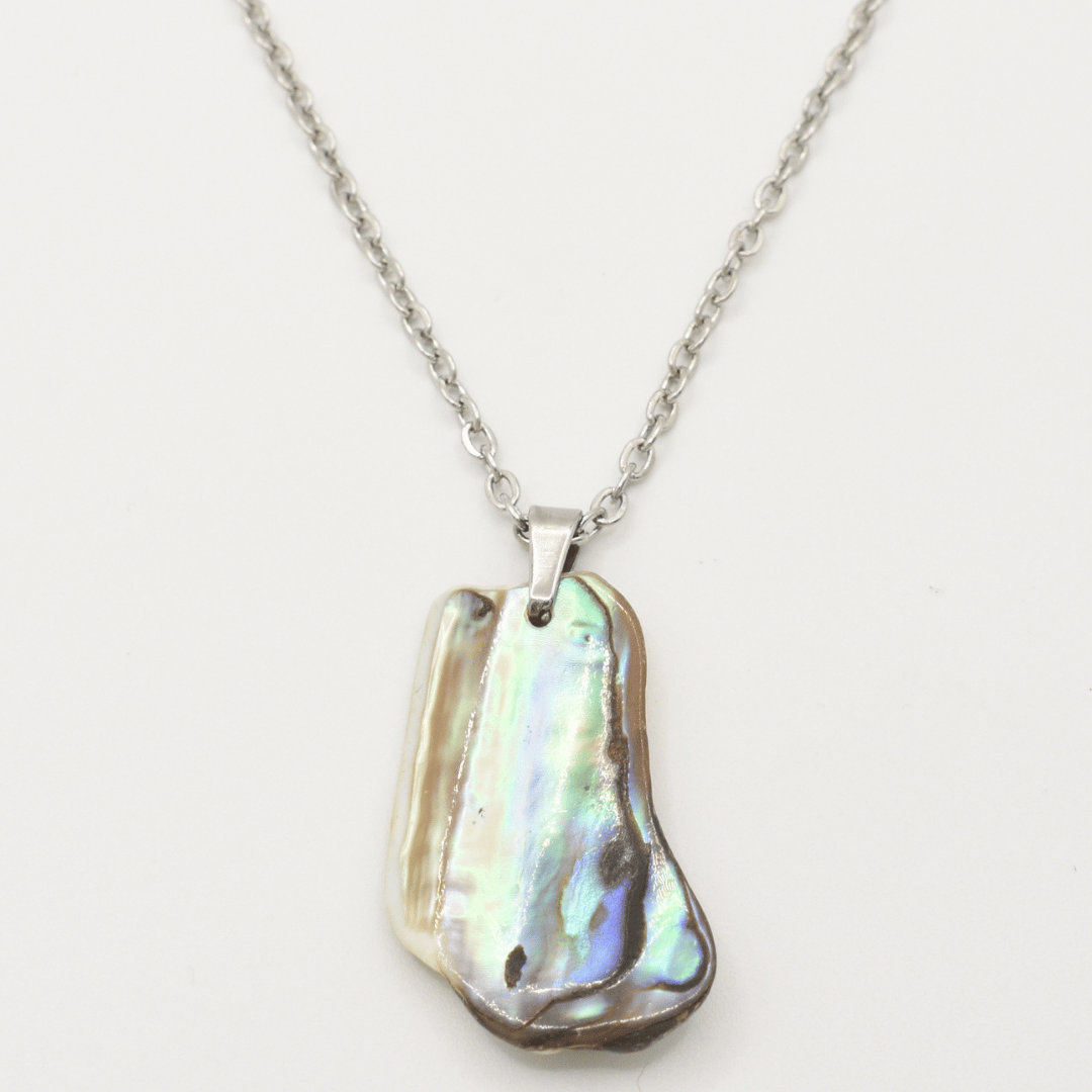 The Salty Dreamers Necklace | Paua Shell Kaukau is a handmade silver chain necklace featuring a polished, irregular abalone shell pendant with iridescent blue, green, and brown hues, shown on a white background.