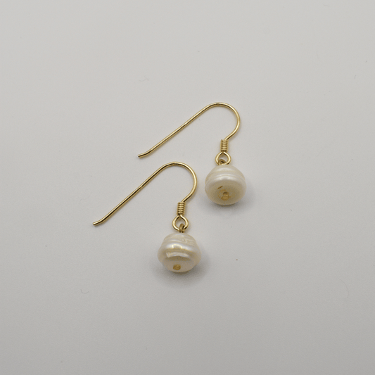 The Pearl earrings by Salty Dreamers feature handmade gold settings with irregular freshwater pearl drops, shown on a plain white background.