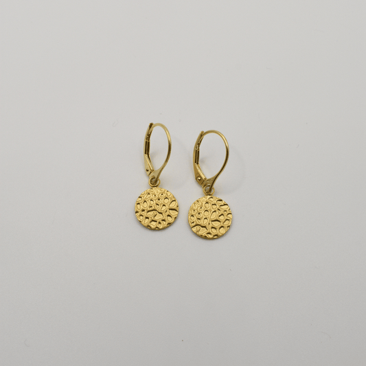 Salty Dreamers Earrings | Gold Circle: Lightweight gold leverback earrings with round, textured dangle charms featuring a raised geometric pattern, shown on a plain white background.