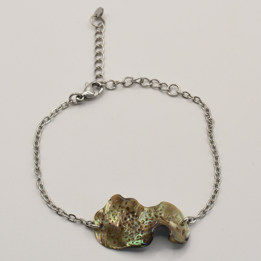 The Salty Dreamers Bracelet | Paua Shell Ra showcases an irregular, iridescent paua shell centerpiece on a silver chain, set against a plain white background.
