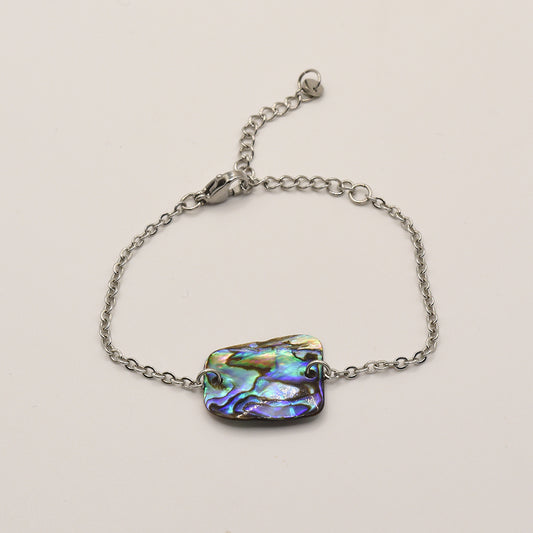 The Bracelet | Paua Shell Marama by Salty Dreamers is a handmade silver chain bracelet with a vibrant pāua shell centerpiece, inspired by New Zealand jewelry traditions and shown on a plain white background.