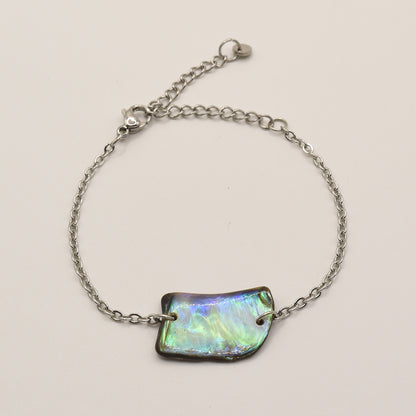 The Bracelet | Paua Shell Atarau by Salty Dreamers features a delicate handmade silver chain, an iridescent rectangular pāua shell centerpiece, and a lobster clasp, shown on a plain light background.