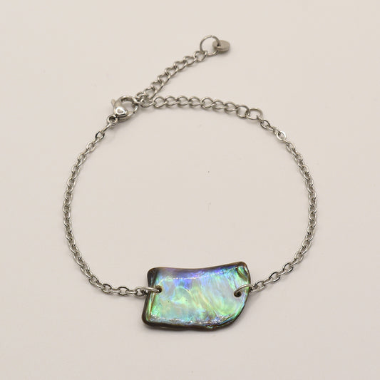 The Bracelet | Paua Shell Atarau by Salty Dreamers features a delicate handmade silver chain, an iridescent rectangular pāua shell centerpiece, and a lobster clasp, shown on a plain light background.
