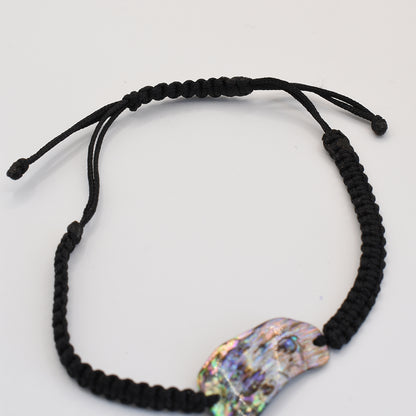 The Salty Dreamers Bracelet | Paua Shell Uru is a handmade black macrame bracelet with a striking New Zealand pāua shell centerpiece, shown on a plain white background.