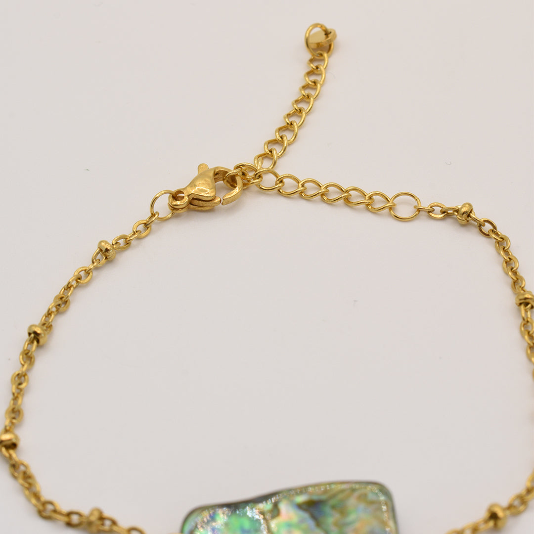 The Bracelet | Paua Shell Whakaora by Salty Dreamers features an iridescent pāua shell centerpiece with a gold chain, adjustable extender, and lobster clasp—ideal for those who love unique mother-of-pearl jewelry.