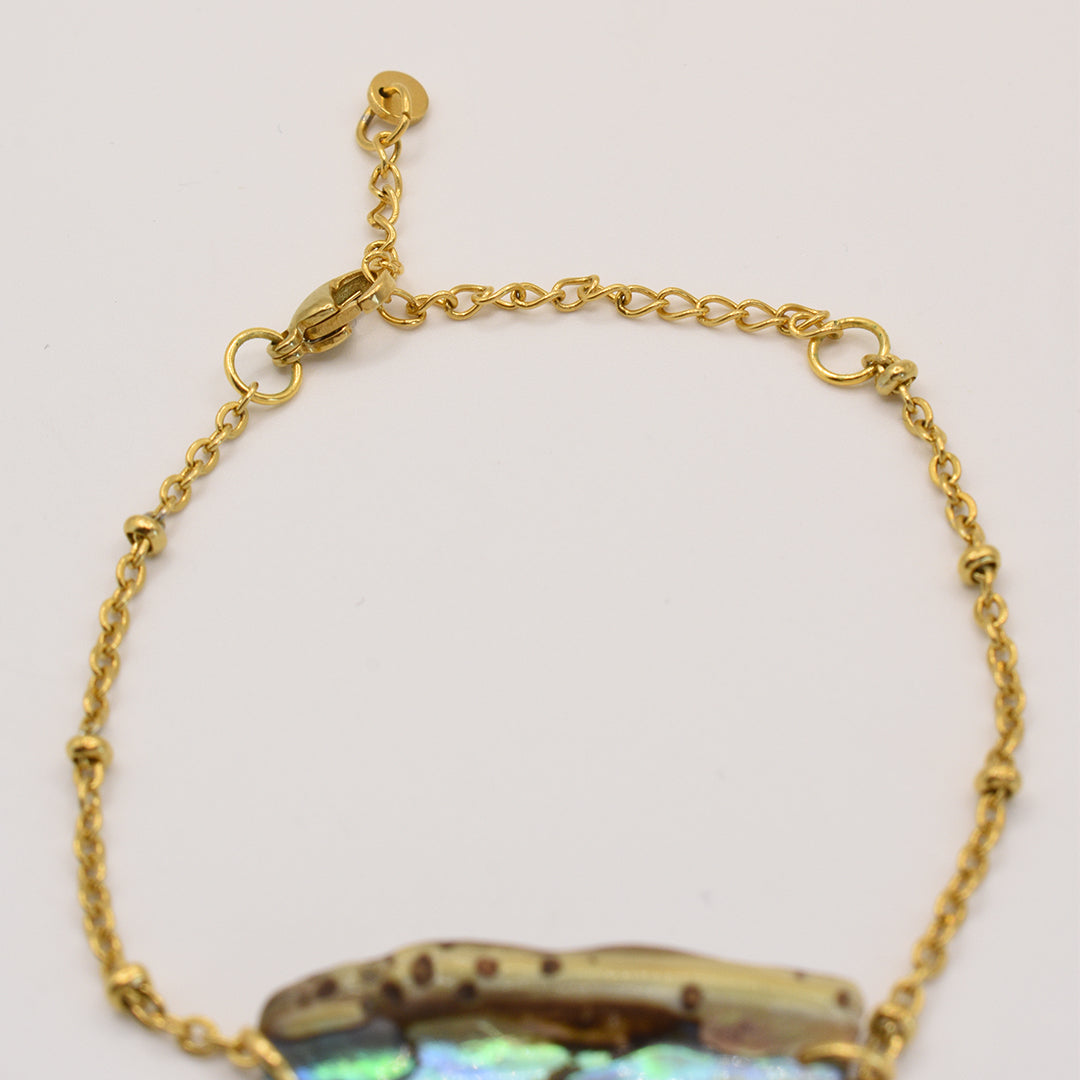 A close-up of the Salty Dreamers Bracelet | Paua Shell Kaukau reveals its delicate gold chain, lobster clasp, and paua shell detail, highlighting the elegance of New Zealand design against a plain light background.