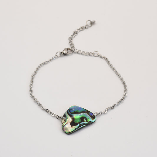 The Bracelet | Paua Shell Tai by Salty Dreamers features an iridescent New Zealand abalone centerpiece on a delicate silver chain—ideal handmade ocean jewelry for any collection.