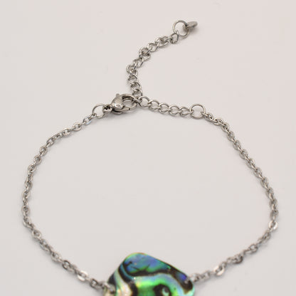 The Salty Dreamers Bracelet | Paua Shell Tai features a delicate silver chain, adjustable clasp, and vibrant pāua shell centerpiece. This handmade ocean-inspired jewelry piece is displayed on a plain white background.