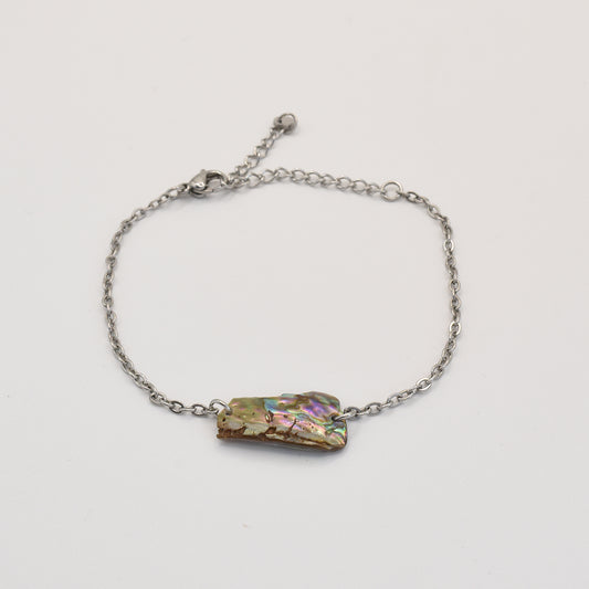 The Salty Dreamers Bracelet | Paua Shell Hine is a handmade silver chain bracelet with an iridescent pāua shell charm, showcased on a plain white background.