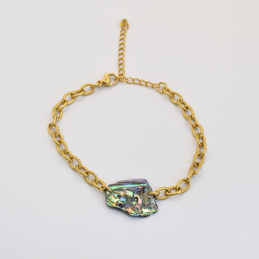 The Bracelet | Paua Shell Kowhai by Salty Dreamers features a gold chain with a lobster clasp, adjustable extender, and a striking iridescent pāua shell centerpiece, shown on a plain white background as dazzling abalone jewelry.