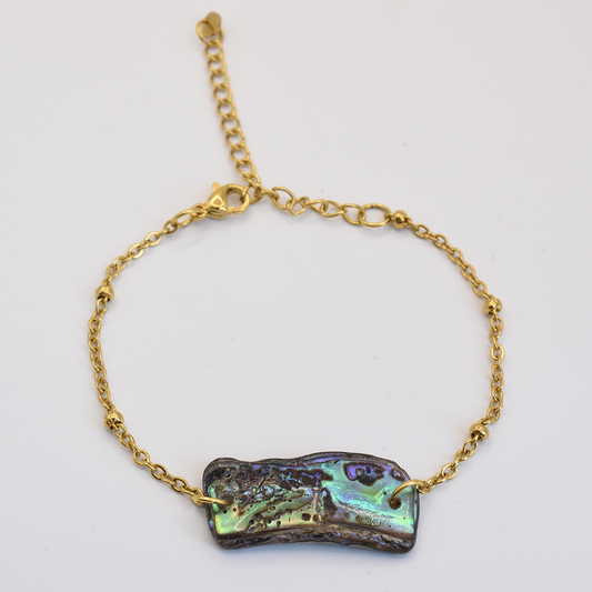 The Salty Dreamers Bracelet | Paua Shell Kiri features a delicate gold chain with an iridescent rectangular paua shell, lobster clasp, and adjustable length, shown on a white background.